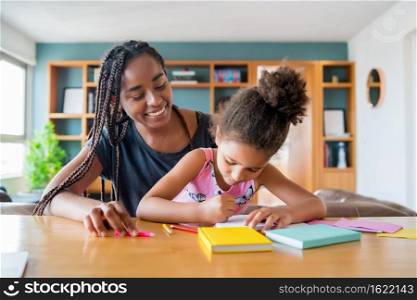 Mother helping and supporting her daughter with homeschool while staying at home. New normal lifestyle concept. 