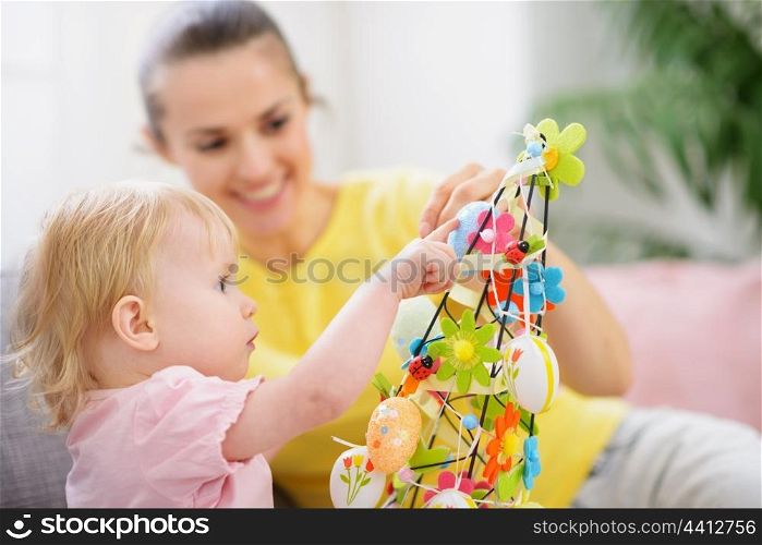 Mother helping baby made Easter decoration