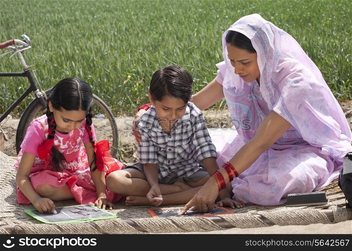 Mother helping daughter and son with their homework