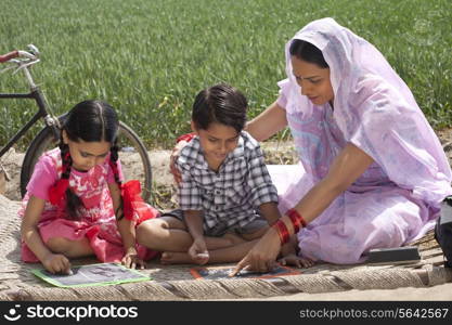 Mother helping daughter and son with their homework