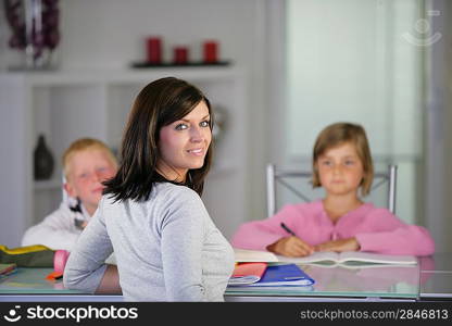 Mother helping her children with their homework