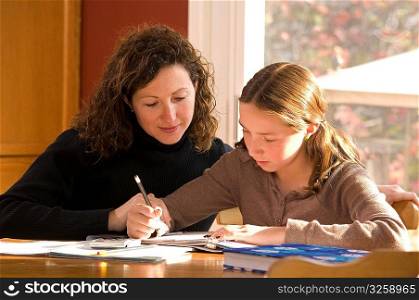 Mother helping her daughter with her school homework.