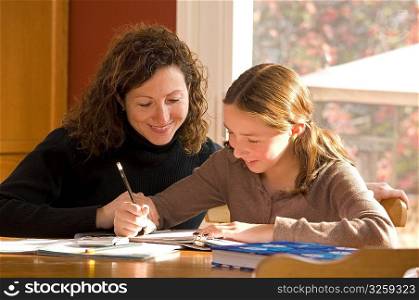 Mother helping her daughter with her school homework.
