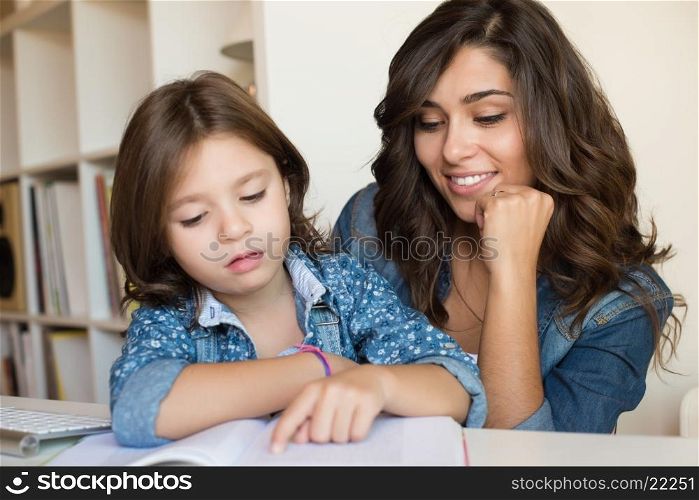 Mother helping her little child with homework