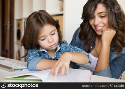 Mother helping her little child with homework