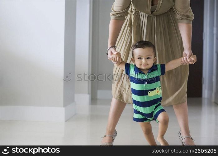 Mother helping her son in walking