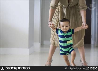 Mother helping her son in walking