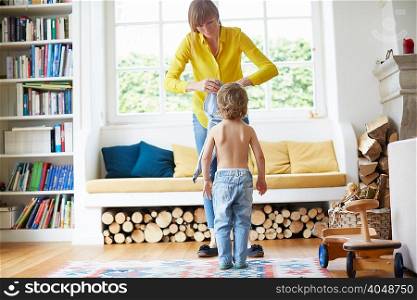 Mother helping son to get dressed