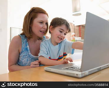 Mother Helping Son Use Laptop