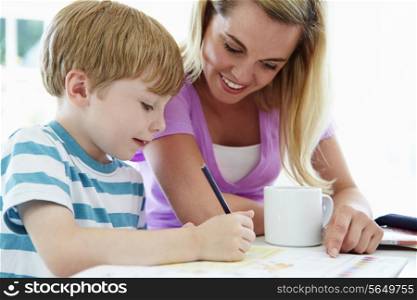 Mother Helping Son With Homework In Kitchen