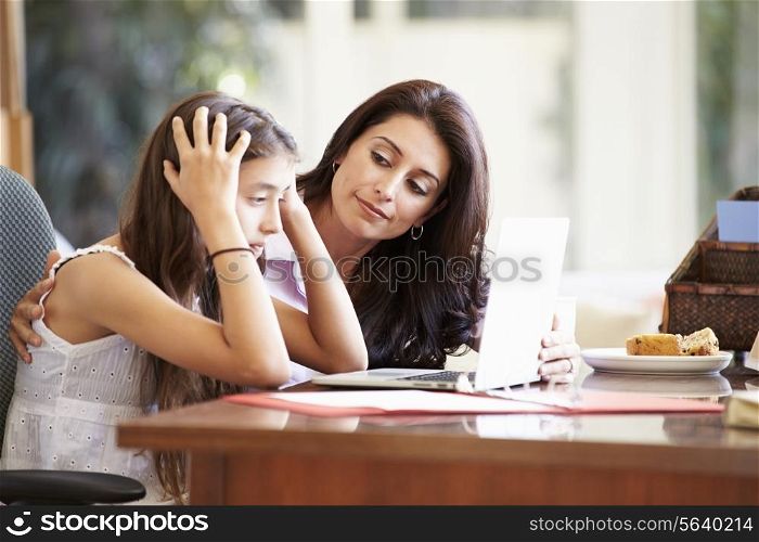 Mother Helping Stressed Teenage Daughter Looking At Laptop