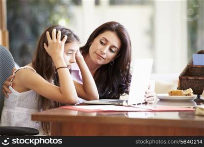 Mother Helping Stressed Teenage Daughter Looking At Laptop