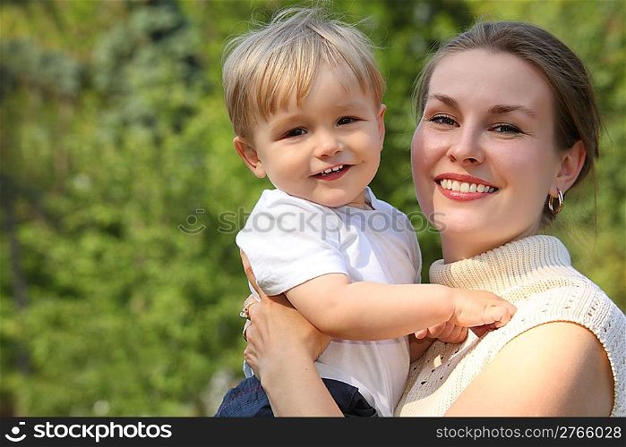 Mother hold baby on hands outdoor in summer