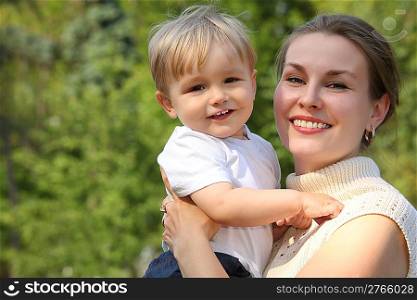 Mother hold baby on hands outdoor in summer