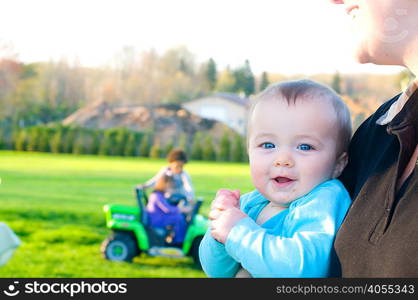 Mother holding baby girl, outdoors, mid section