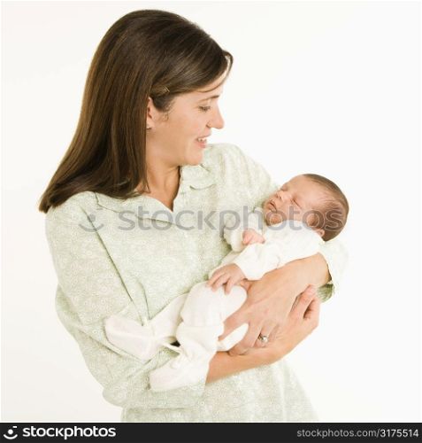 Mother holding baby smiling against white background.