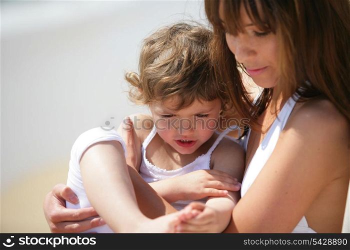 Mother holding daughter at the beach
