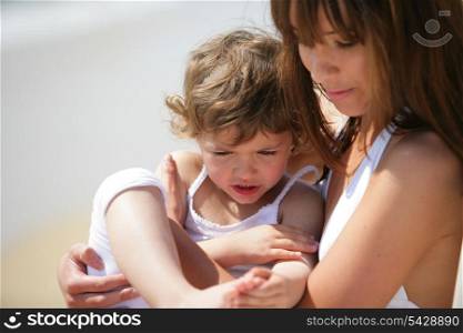 Mother holding daughter at the beach