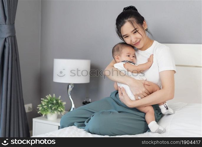 mother holding newborn baby in a tender embrace on a bed