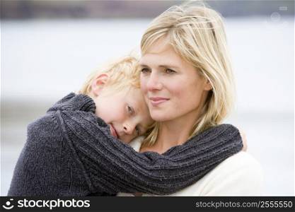Mother holding son at beach smiling
