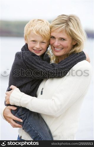 Mother holding son at beach smiling