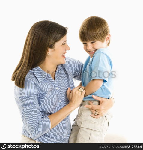 Mother holding son laughing against white background.
