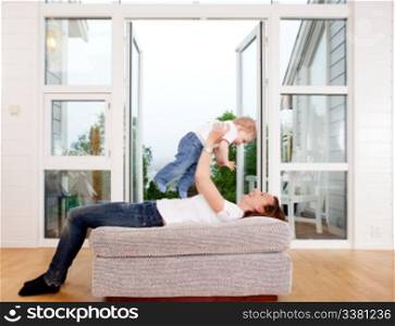 Mother holding son over head playing and having fun at home