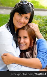 Mother holding teen daughter in her arms happy bonding park