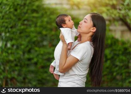 mother holding with her baby newborn in the garden