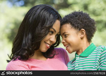 Mother holding young son looking into eachother&acute;s eyes and smiling.