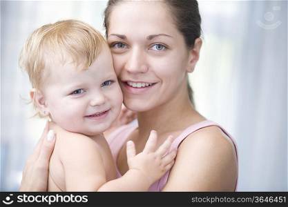 Mother holds blonde toddler with pride