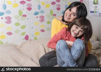 mother hugging daughter from bed