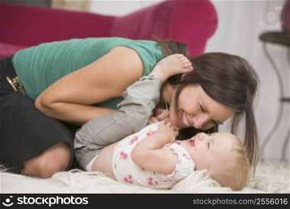 Mother in living room playing with baby smiling