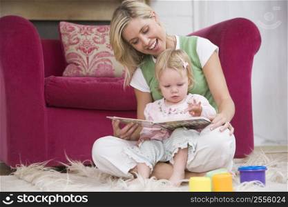 Mother in living room reading book with baby smiling