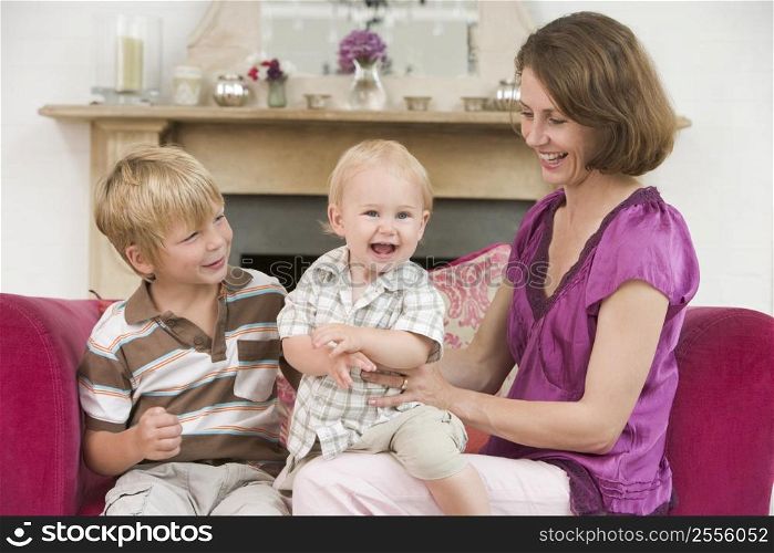 Mother in living room with baby and young boy smiling