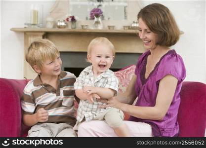 Mother in living room with baby and young boy smiling