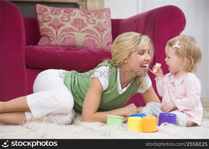 Mother in living room with baby eating banana and smiling