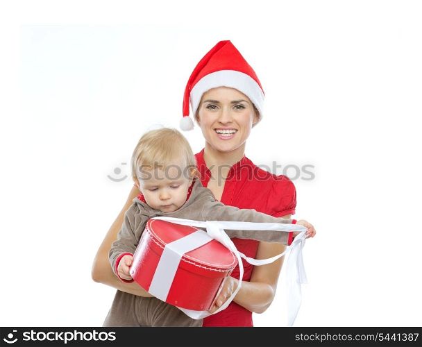 Mother in Santa&rsquo;s hat holding baby opening Christmas present