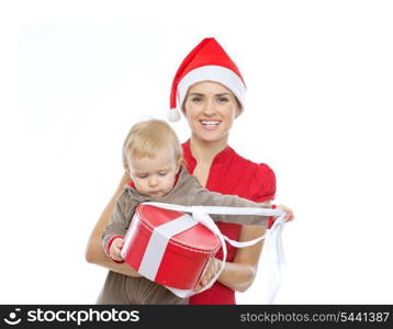 Mother in Santa&rsquo;s hat holding baby opening Christmas present