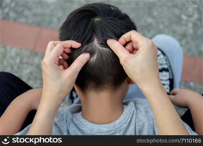 Mother is catching hair to find lice and treatment hair in children.