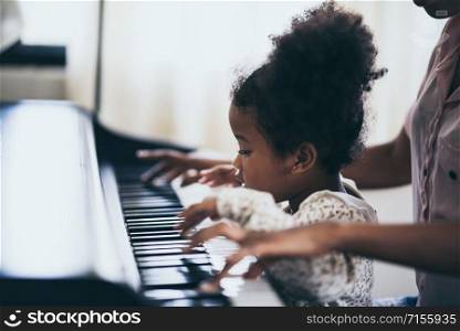 Mother is teaching piano tricks, African people