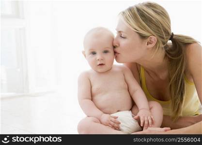 Mother kissing baby indoors