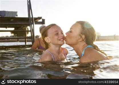 Mother kissing daughter