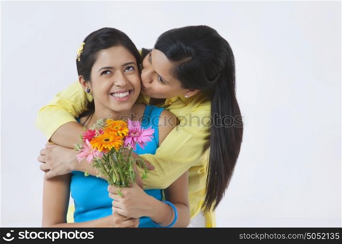 Mother kissing her daughter on cheek
