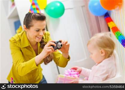 Mother making photos at babies birthday party