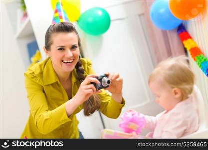 Mother making photos of babys first birthday