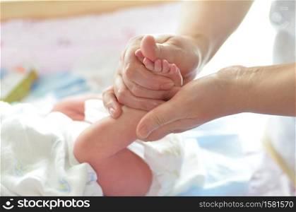 Mother massaging her child&rsquo;s foot, shallow focus