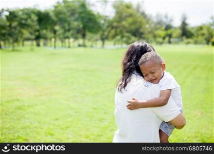 Mother of mixed African American boy carrying her kid in the park. Mother of mixed African American boy carrying her kid in the park.