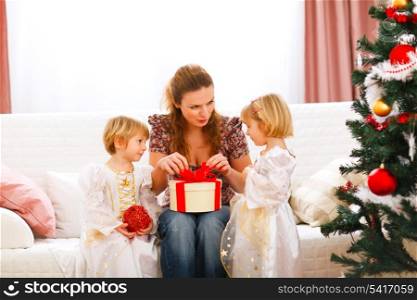Mother opening gift presented by twins girl
