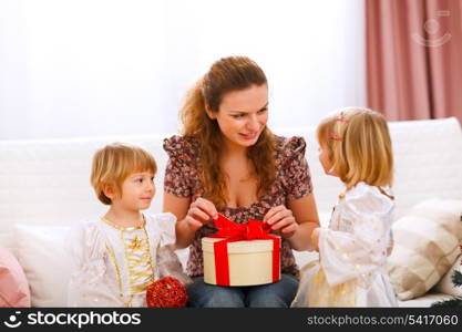 Mother opening gift presented by twins girl